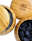 Top view of Go Bowls & Stones Set with lids lifted off 2 bamboo bowls showing black and white ceramic go stones