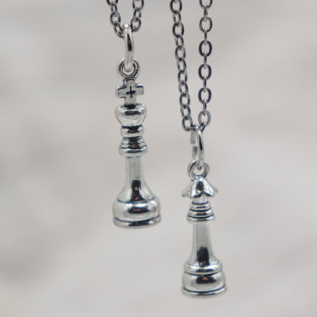 Silver pendant necklace with a King or Queen chess piece charm in antique silver-tone finish link chain.