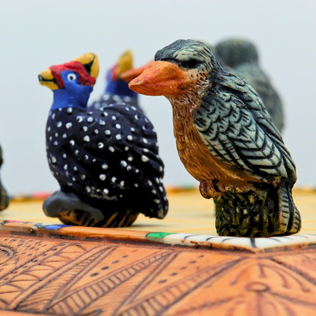 Close up of African Bird Noughts &amp; Crosses resin game set with hand-painted birds showcasing Kingfisher &amp; Guineafowl pieces