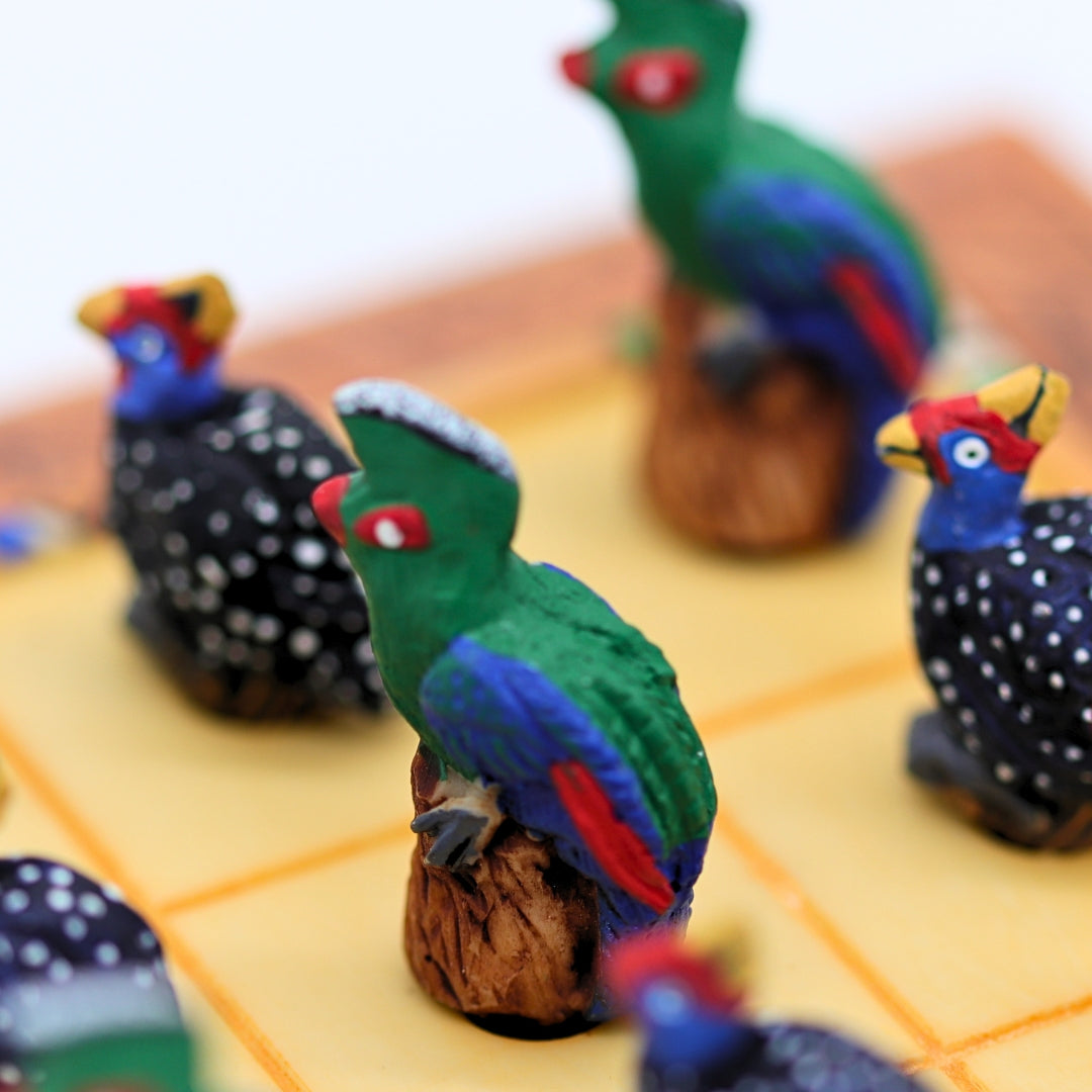 Close up of African Bird Noughts &amp; Crosses resin game set with hand-painted birds showcasing Loerie &amp; Guineafowl pieces